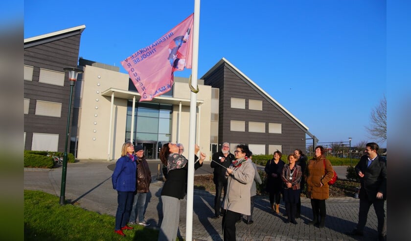 Vlag voor Internationale Vrouwendag wappert bij Thools gemeentehuis