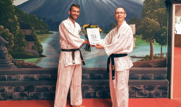 Sensei Alwin Ikink (r) feliciteert Erik Wolterink (l) met zijn jubileum.