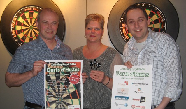 Arjan Kocken (links), De Tuunte-horecamedewerkster Patrice van Zuidam en Niels Blikman tonen posters die worden gebruikt om Darts d´Huzes te promoten. Foto: Bart Kraan