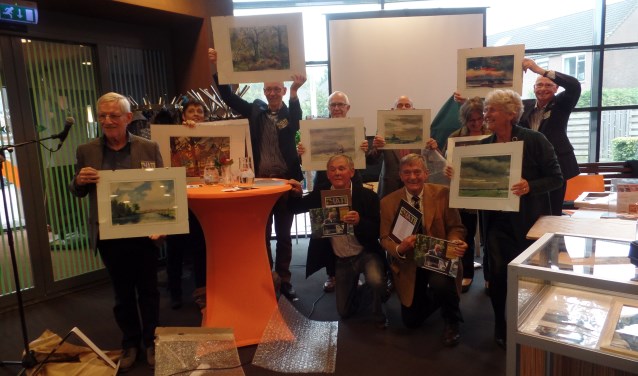 De kinderen van Thate schenken een schilderij aan de vrijwilligers. Foto: Meike Wesselink