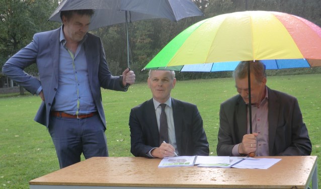 Peter van de Wardt (r) en Henk van der Esch tijdens de ondertekening in de regen. Foto: Walter Hobelman