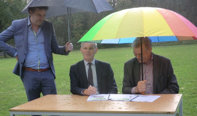 Peter van de Wardt (r) en Henk van der Esch tijdens de ondertekening in de regen. Foto: Walter Hobelman