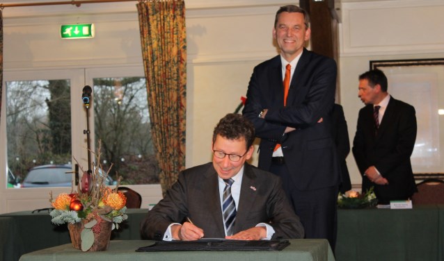 Anton Stapelkamp wacht lachend tot Commissaris van de Koning, Clemens Cornielje, zijn installatie met een handtekening heeft bekrachtigd. Foto: Leo van der Linde