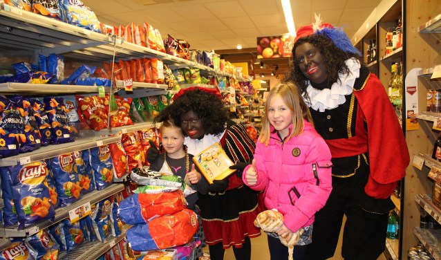 Fenna met het volle winkelwagentje samen met zus Tesse en de pieten. Foto: Marlous Velthausz