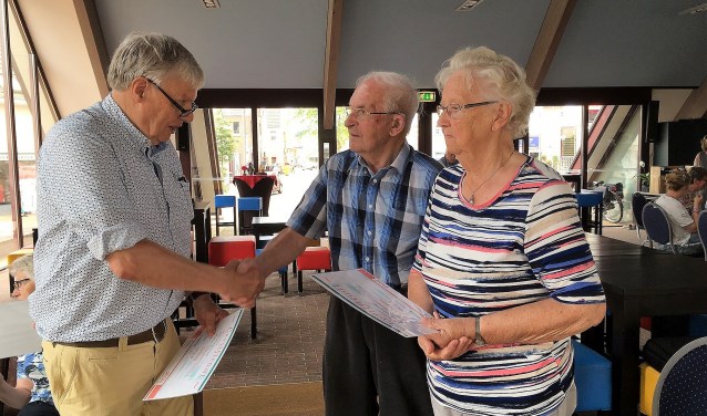 Coördinator Gerard Wesseling reikt het certificaat uit aan de 85-plussers mevrouw Gesink en de haar Davids. Foto: PR