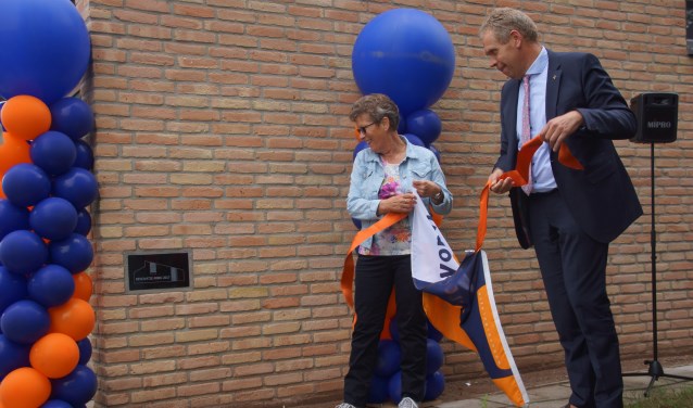 Gerda van der Meij van de bewonerscommissie onthult samen met wethouder Spekschoor de plaquette aan de buitenmuur van de huurwoning aan de Hoetinkhof 2 in Vorden. Foto: Bernadet te Velthuis