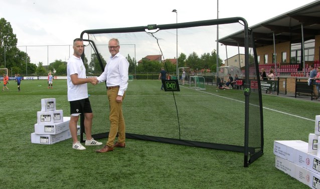 Marcel Dijk, rechts, overhandigt VIOD jeugdtrainer Jos Mekkes 8 pupillendoeltjes. Foto: PR