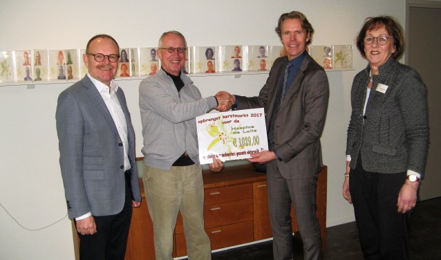 Gemeensecretaris Alwin Oortgiesen (tweede van rechts) overhandigt voorzitter Hans ten Kate van hospicegroep De Lelie de symbolische cheque voor 1029 euro. Penningmeester Johan Teeuwsen en coördinatrice Joke Verweij kijken toe. Foto: Bart Kraan