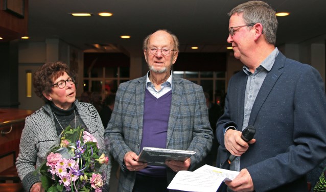 Gerard Schepers (m.) en zijn vrouw Annie werden tijdens de nieuwjaarsbijeenkomst in het zonnetje gezet door voorzitter Henk Sleumer. Foto: PR