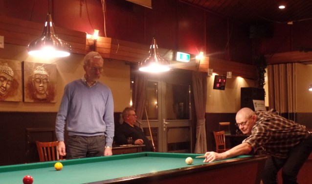 Onder toeziend oog van teller Jan Ras legt Frits Berendsen de keu aan voor het driebanden kampioenschap. Foto: Jan Hendriksen