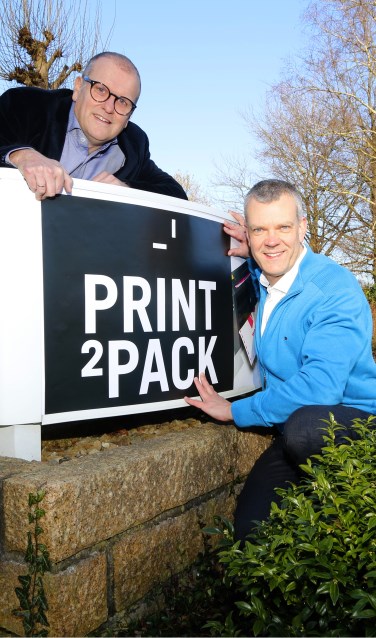 Rob van Dijk (links) en Gerhard Weevers bij het nieuwe logo van Print2Pack. Foto: Dominique Weevers