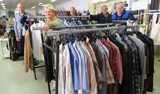 Enkele vrijwilligers met geheel links Jan ter Dolle in de Vincentius-winkel. Foto: Theo Huijskes
