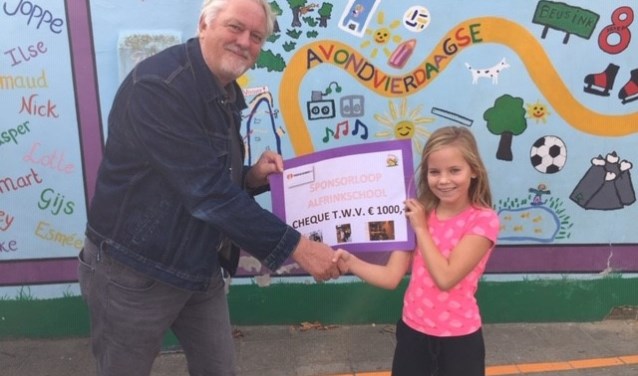 De cheque wordt door één van de leerlingen overhandigd. Foto: PR