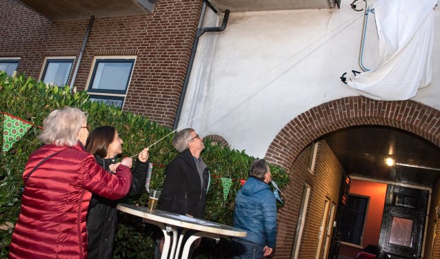 Harmke Schalkwijk en Marie-Nour Hartman onthullen het logo aan het Wöhrmannhofje. Foto: Willem Feith