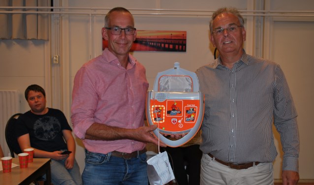 Jan Willem Jolink, voorzitter van buurtvereniging Wassinkbrink, neemt de AED in ontvangst van de firma Cardi Aid. Foto: Margreet Nusselder