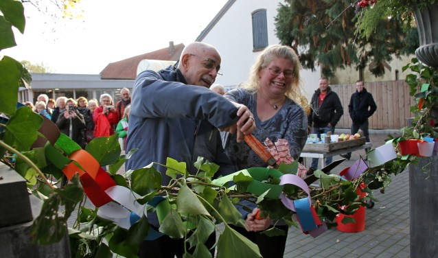 Meester Arnold Janssen helpt Josja van Mierlo met de officiële opening van haar bloemenlokaal. Foto: Liesbeth Spaansen