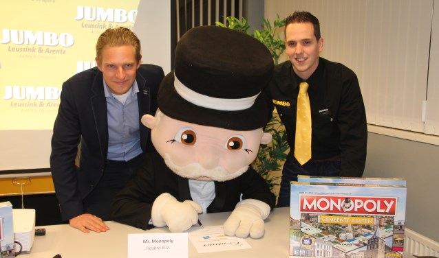 Tijn Leussink (links) en Dennis Klompenhouwer kijken toe hoe 'Mr Monopoly' de overeenkomst voor de levering van meer spellen ondertekent. Foto: Lydia ter Welle