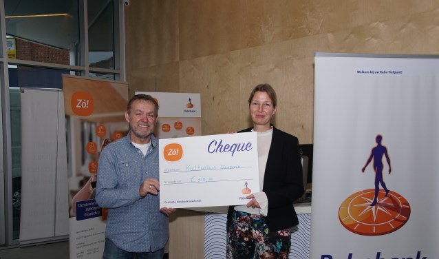 Theo Janssen en Tamara Elburg tonen de symbolische cheque die zij ontvingen van de Rabobank. Foto: Frank Vinkenvleugel