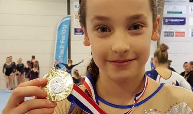 Lina toont trots haar gouden medaille.