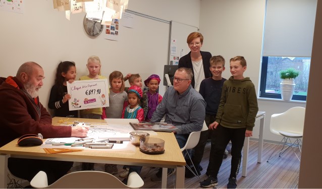 Leerlingen overhandigen een cheque voor een groener schoolplein. Foto: Imalda Dragt