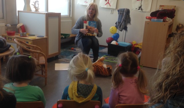 Peuters luisteren naar voorlezer Jenny van de bibliotheek. Foto: Saskia te West