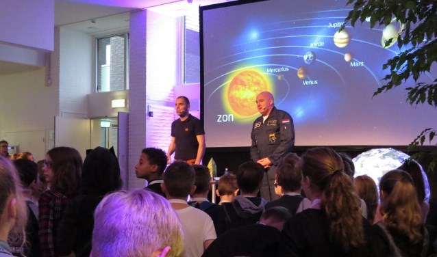 André Kuipers en Sander Koenen (links) gooiden zojuist een balletje de zaal in om uit te leggen hoe een raket het handigst in een baan om de aarde kan worden gebracht. Foto: Josée Gruwel
