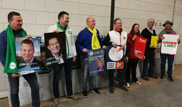 De lijsttrekkers staan klaar om hun affiches aan te plakken. Foto: Rob Weeber