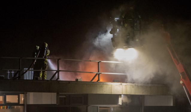 Brandweerlieden blussen op het dak van de flat aan de Caenstraat. Foto: News United/112 Achterhoek Nieuws