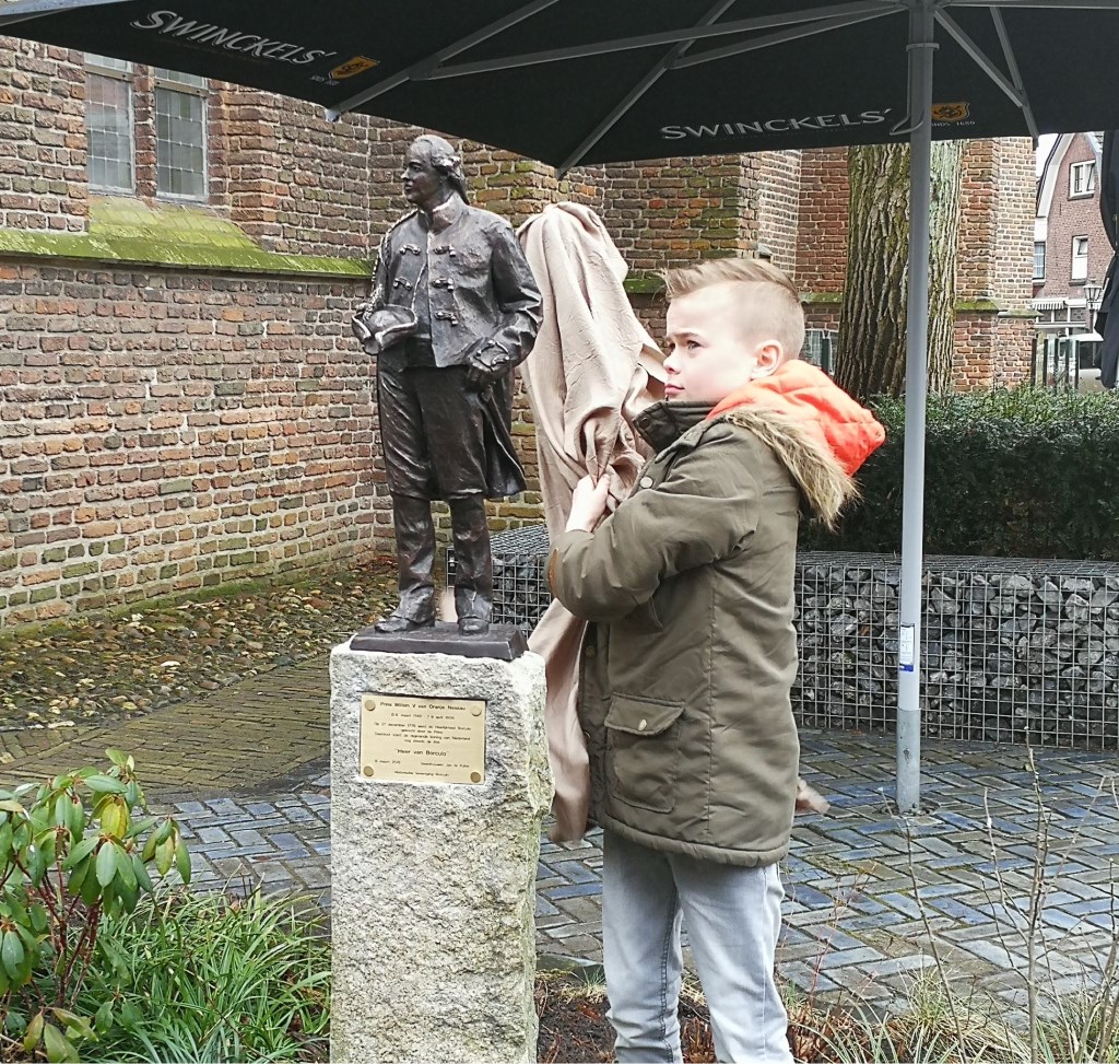 De vijfde generatie 'Willem' Nieuwenhuis, zoon Marc Cornelis Willem, onthult het beeld van Willem V. Foto: Rob Weeber