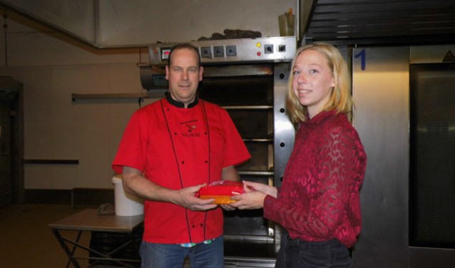 Femke Elferink overhandigt de cake aan bakker Gerard Vaags. Foto: Eva Schipper