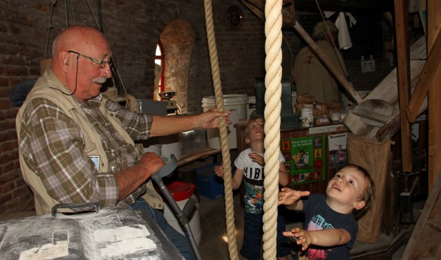 Molenaar Gerard Brugman laat kleinzoons Nik en Tim beleven hoe het luien gaat. Foto: Liesbeth Spaansen