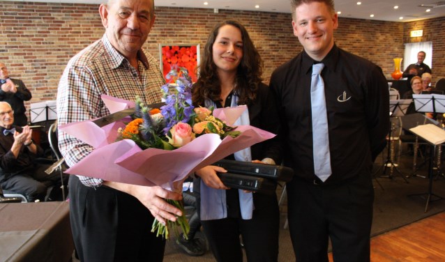 Bloemen als bedankje voor opa Bluiminck. Ook op de foto kleindochter Naomi en voorzitter Frank Spiekker. Foto: Nora Baks