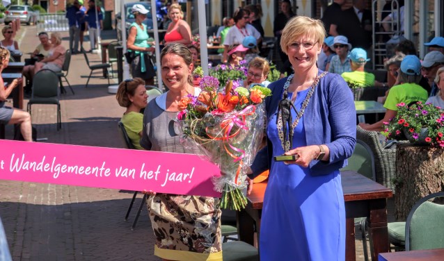 Burgemeester Marianne Besselink toont het beeldje dat hoort bij de titel Wandelgemeente van het jaar 2018. Foto: Luuk Stam