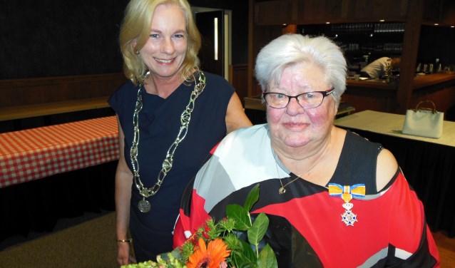 Geflankeerd door burgemeester Annemieke Vermeulen toont Cootje van der Meulen haar zojuist opgespelde Koninklijke Onderscheiding. Foto: Eric Klop