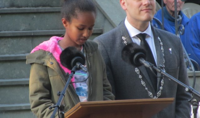 Suzie uit het asielzoekerscentrum leest een gedicht voor. Naast haar burgemeester Bengevoord. Foto: Bernhard Harfsterkamp