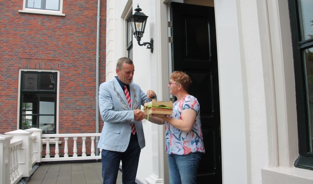 Burgemeester Stapelkamp neemt de kersen in ontvangst van Astrid Selman en laat ze zich goed smaken. Foto: Lydia ter Welle