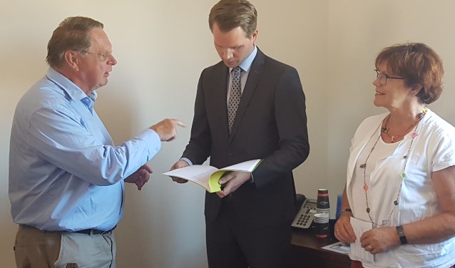 Jaap Cannegieter (l) biedt de petitie aan aan wethouder Bart Porskamp. Rechts Wilma van der Donk. Foto: Kyra Broshuis