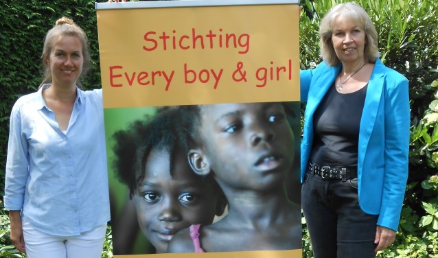 Marjan Koffeman (r) samen met Annerieke Overvelde voor een reclamezuil van Stichting Every boy & girl. Foto: PR.