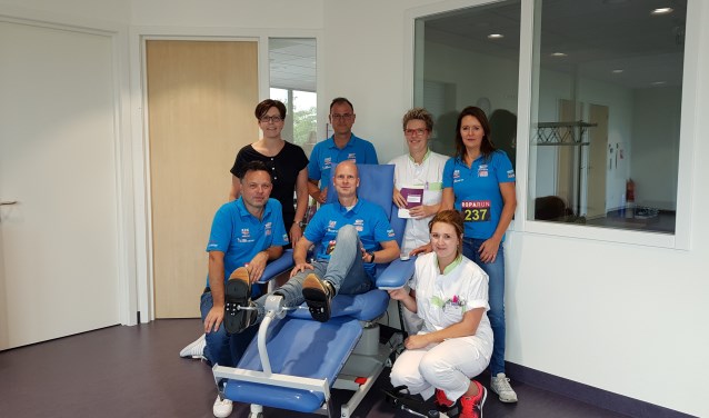 De Roparunners proberen even een 'fiets' uit, die gekoppeld kan worden aan de stoel van de patiënt tijdens een behandeling met chemotherapie. Foto: PR