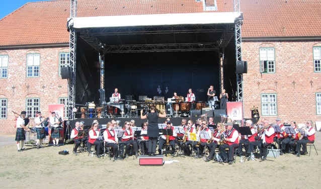Muziekvereniging Volharding tijdens het optreden met een drietal leden van de Frederikshaven FDF Pipeband en Marc Ditters en Sandra Halfman. Foto: PR