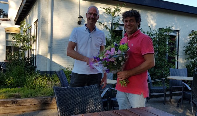 Hidde Bulten overhandigt het boeket bloemen aan Bert Ribbers. Foto: PR