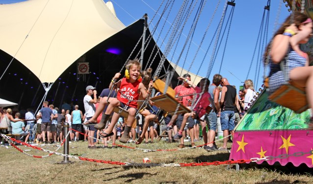 Blagen zwieren in de zweefmolen met zicht op høkers in de nieuwe overdekte concertzaal. Foto: Liesbeth Spaansen