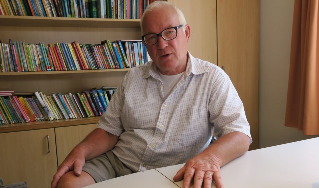 Hans van Loosen, gezeten achter zijn bureau in de directiekamer van basisschool St. Ludgerus in Zwolle. Foto: Theo Huijskes