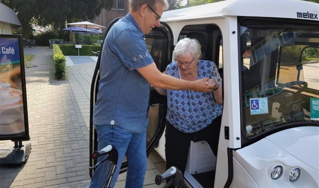 Vrijwilliger Jan Bongaarts helpt mevrouw Poelhuis uit de electrocar.