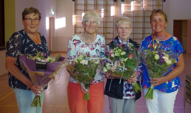 Diny Klompenhouwer, in de bloemetjes gezet vanwege haar grote verdiensten voor de zangvereniging, met naast de jubilarissen Willey Weenink en Sien Beernink, dirigente Riet Lieverdink (vlnr). Foto: G. W. Huinink