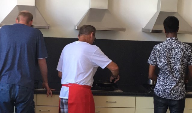 Mannen met pannen in de weer. Foto: PR