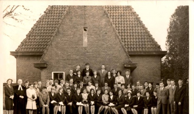 De belijdeniscatechisanten uit 1966 voor de voormalige pastorie aan de Domineesteeg met onder meer dominee Barnard .Foto: PR.