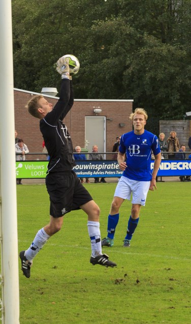 Lucas Breukelaar kijkt toe hoe Varsseveld-doelman Joost Riewald de bal uit de lucht plukt. Foto: Henk Kok/Voorwaarts Twello