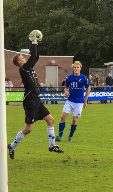 Lucas Breukelaar kijkt toe hoe Varsseveld-doelman Joost Riewald de bal uit de lucht plukt. Foto: Henk Kok/Voorwaarts Twello