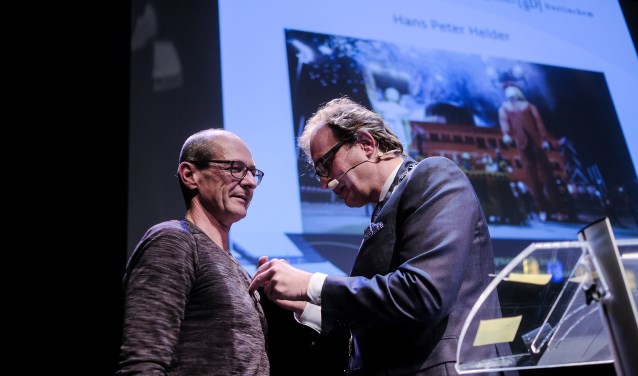 Burgemeester Boumans speldt de eremedaille op bij Hans Peter Helder. Foto: Jan van den Brink